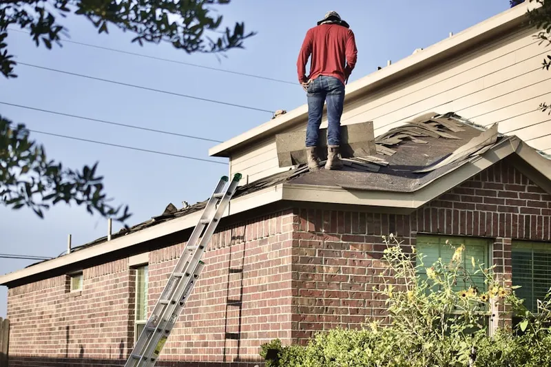 Professional roofer working on a residential roof in Northwood